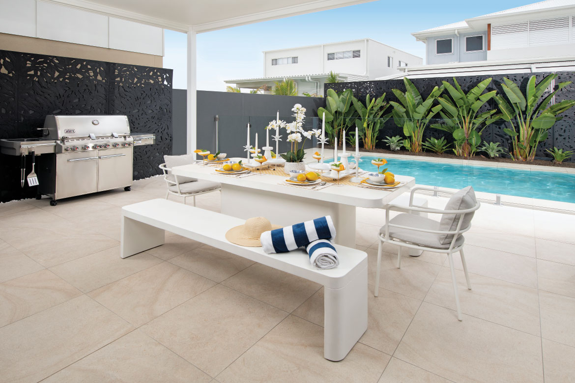 Alfresco dining area with a BBQ and a pool.