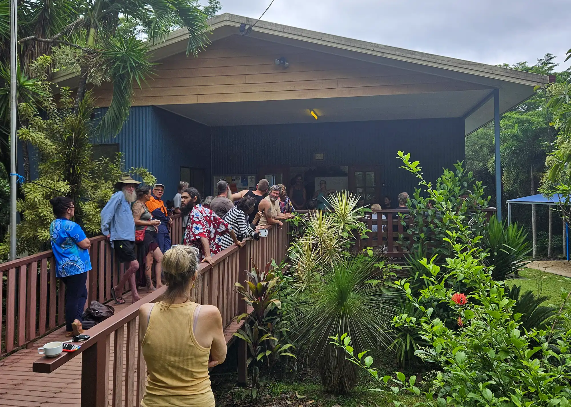 A large group of people lining up to enter a hall to escape poor weather